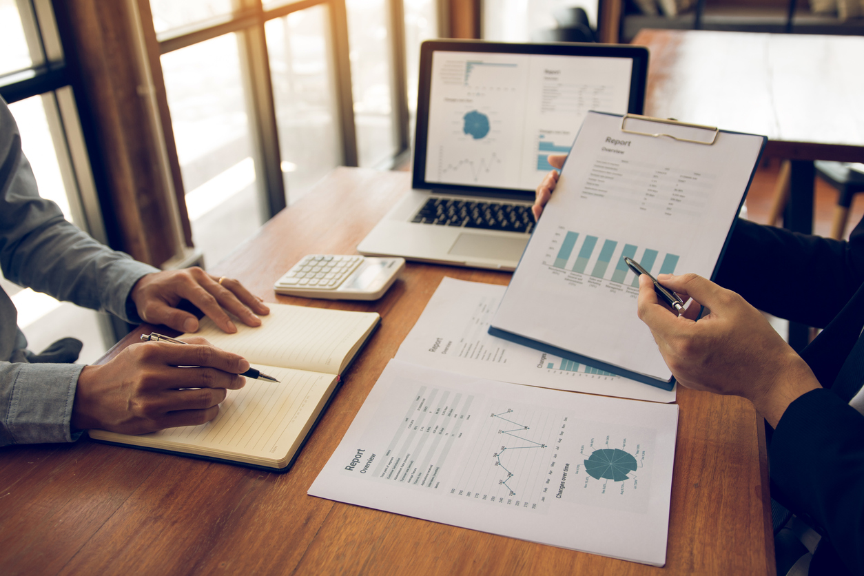 two business partnership coworkers analysis strategy with discussing a financial planning graph and company budget during a budget meeting in office room.